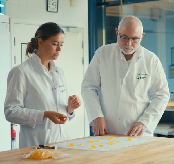Woman and man evaluating gummy candies on table
